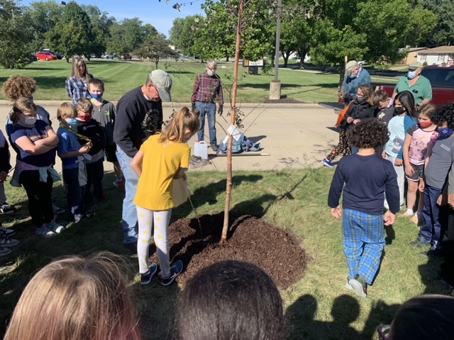 Picture of 3rd graders planting a tree